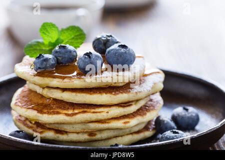 Crêpes au babeurre de bleuets dans poêle en fonte servi chaud avec du sirop d'érable sur la table en bois rustique, petit-déjeuner sain Banque D'Images