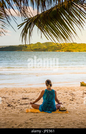 Playa Rincon, Péninsule de Samana, République dominicaine. Woman practicing yoga sur la plage. Banque D'Images