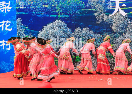 La femme chinoise habillé avec des vêtements traditionnels danser et chanter pendant le festival des Fleurs Poire Qifeng Heqing, Chine Banque D'Images