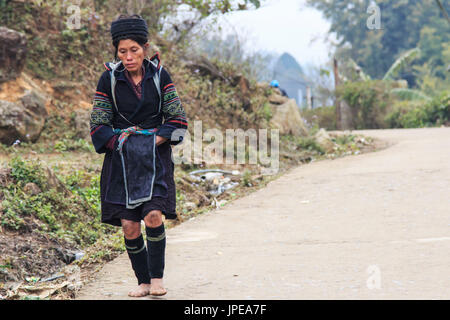 Femme autochtone des montagnes de Sapa, dans le nord du Vietnam, vêtue du costume traditionnel de son village à pied Banque D'Images