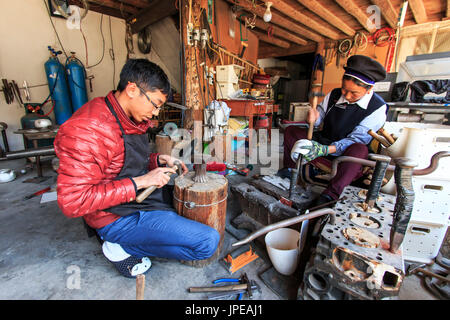 Jeune orfèvre travaille sur son atelier avec une autre femme vêtue du costume traditionnel de Bai. Yunnan, Chine Banque D'Images