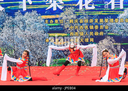 La femme chinoise habillé avec des vêtements traditionnels danser et chanter pendant le festival des Fleurs Poire Qifeng Heqing, Chine Banque D'Images