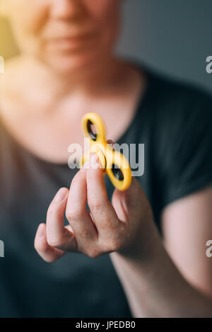 Femme jouant avec fidget spinner, très populaires jouets modernes pour la détente et le soulagement du stress Banque D'Images