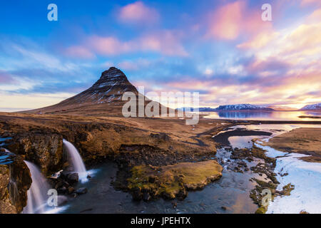 Printemps le lever du soleil sur la célèbre chute d'Kirkjufellsfoss avec en toile de fond la montagne Kirkjufell en Islande Banque D'Images