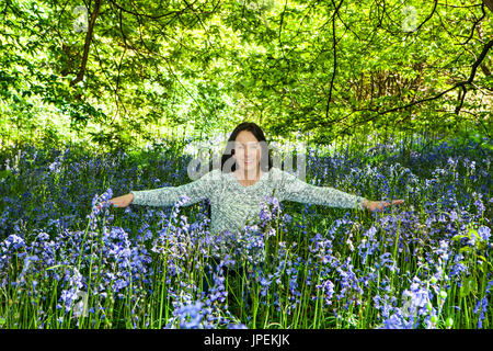 Femme avec bras étendus en bois Bluebell Banque D'Images