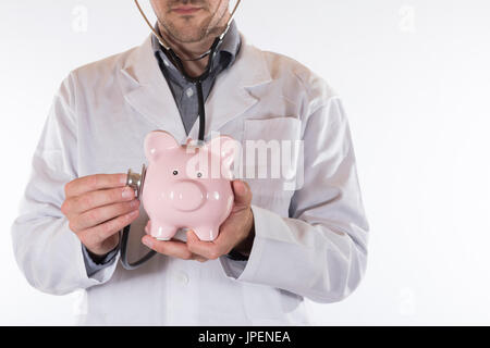 Vue avant sur l'homme médecin non identifiables en sarrau blanc avec stéthoscope sur piggy bank Banque D'Images