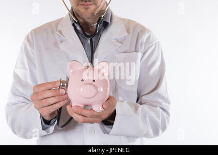 Vue avant sur l'homme médecin non identifiables in lab coat with stethoscope sur piggy bank Banque D'Images