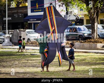 Ubud, Bali, Indonésie. 1er août 2017. Un homme porte sa bebean (cerf-volant en forme de poisson) sur le terrain de soccer de l'école publique à Ubud. Le cerf-volant est un passe-temps populaire sur Bali. Il avait des connotations religieuses, il a été utilisé pour poser les dieux pour les pluies abondantes et de bonnes récoltes. Les petites, piloté par des particuliers sont d'environ deux mètres de long, les plus grandes équipes de vol jusqu'à 80 personnes a 10 mètres de long. Il y a trois formes de cerfs-volants traditionnels, bebean (en forme de poisson), en forme d'oiseaux (janggan) et pecukan (en forme de feuille). Credit : ZUMA Press, Inc./Alamy Live News Banque D'Images