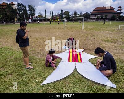 Ubud, Bali, Indonésie. 1er août 2017. Cerfs-volistes se préparer à battre leur bebean (poisson) en forme de cerf-volant sur le terrain de soccer de l'école publique à Ubud. Le cerf-volant est un passe-temps populaire sur Bali. Il avait des connotations religieuses, il a été utilisé pour poser les dieux pour les pluies abondantes et de bonnes récoltes. Les petites, piloté par des particuliers sont d'environ deux mètres de long, les plus grandes équipes de vol jusqu'à 80 personnes a 10 mètres de long. Il y a trois formes de cerfs-volants traditionnels, bebean (en forme de poisson), en forme d'oiseaux (janggan) et pecukan (en forme de feuille). Credit : ZUMA Press, Inc./Alamy Live News Banque D'Images