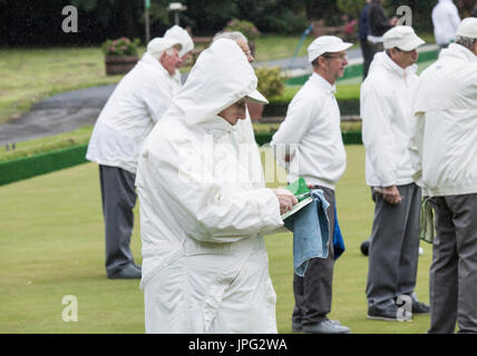 Billingham, Angleterre du Nord-Est, Royaume-Uni. 2 Août, 2017. Météo France : quoi de plus britannique que bols dans la pluie au milieu de l'été. Membres de Billingham bowling club don imperméables et continuer à jouer que heavy rain finalement arrive dans le nord-est de l'Angleterre. Credit : ALAN DAWSON/Alamy Live News Banque D'Images