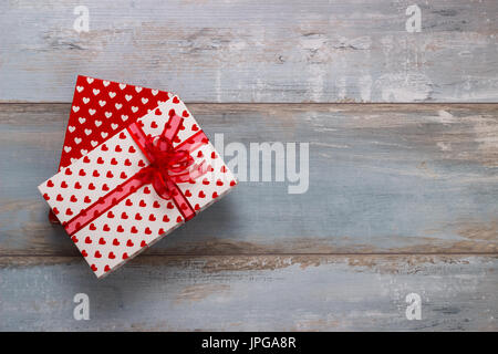 Boîtes cadeaux enveloppés dans du papier avec des rubans polkadots sur fond de bois, vintage retro style Banque D'Images