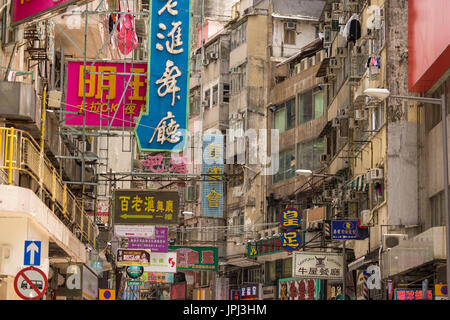 Cacophonie de signes chinois et anglais sur les bâtiments délabrés dans la section commerciale de Kowloon, Hong Kong Banque D'Images