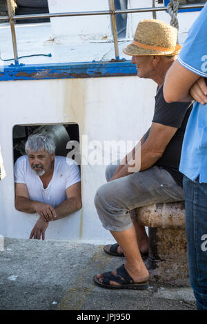 Parler des pêcheurs sur le quai après le retour d'une journée de pêche, dans le port de pêche de Sciacca Southerm en Sicile, Italie. Banque D'Images