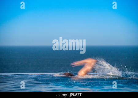 Un adolescent en train d'une piscine à débordement avec mouvements flous Banque D'Images