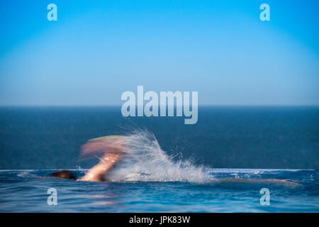 Un adolescent en train d'une piscine à débordement avec mouvements flous Banque D'Images