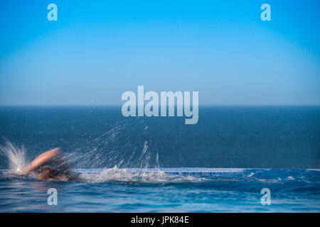 Un adolescent en train d'une piscine à débordement avec mouvements flous Banque D'Images