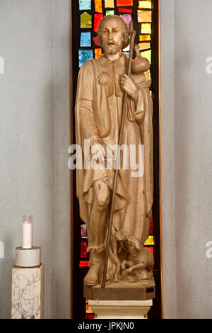 Bois sculpté statue de Saint Roch avec peste bubo sur cuisse et chien avec du pain qui l'a sauvé à Saint Roch's Catholic Church Toronto Canada Banque D'Images