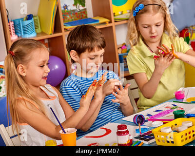 Petite fille aux étudiants la peinture au doigt en art school class. Banque D'Images