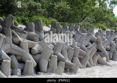 D'énormes blocs de béton empilés avec forme spéciale sont empilés sur une plage de dunes à protéger l'action sinistre des vagues de mer à Kolobrzeg en Pola Banque D'Images