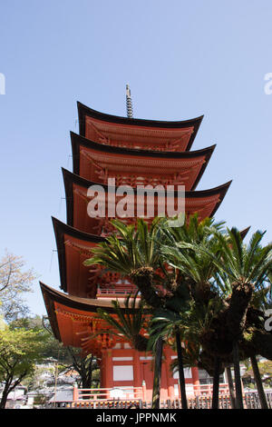 Le GOJU-no-to pagode à Miyajima Japon d'en bas avec des palmiers au premier plan. Banque D'Images
