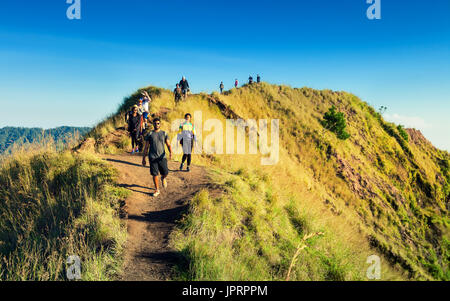 Les attractions populaires de l'île tropicale de bali. Vue de dessus volcan Gunung batur au lever du soleil avec une silhouette ciel nuageux et touristique de randonnée Banque D'Images