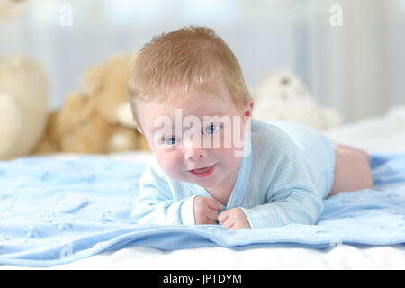 Portrait d'un petit essaie de ramper vers l'appareil photo sur une couverture bleue Banque D'Images