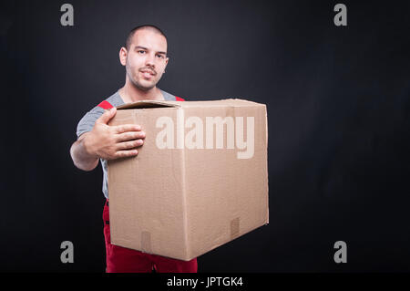 Mover Smiling man holding grande boîte en carton sur le fond avec l'espace texte copie Banque D'Images