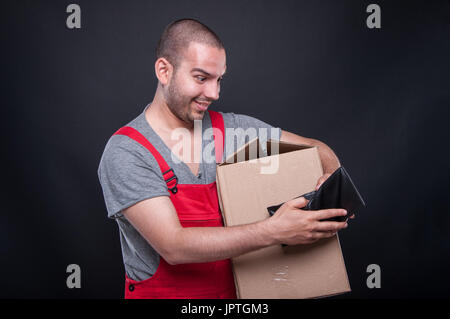 Heureux auteur man holding box et votre portefeuille comme concept jour de paie sur fond noir Banque D'Images