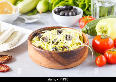 Les pâtes de courgettes aux olives et le tofu. Repas végétarien de légumes et de tofu. L'amour pour une saine nourriture vegan concept. Banque D'Images