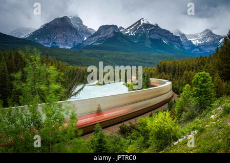 Train dans la courbe de Morant dans Bow Valley avec les Rocheuses en arrière-plan, Banff National Park, Alberta Canada. Longue exposition. Banque D'Images