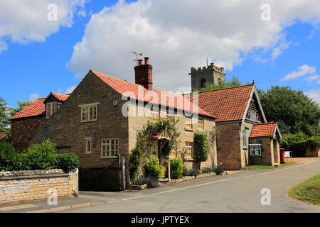 Vue de la rue de l'Église et l'église paroissiale de St Johns, Corby Glen village green, Lincolnshire, Angleterre, RU Banque D'Images