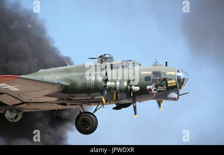 USAF Boeing B-17G Flying Fortress appelé 'Texas Raiders' s'envolent à travers un nuage de fumée noire avec rétraction du train roulant dans l'aéro-afficher Banque D'Images