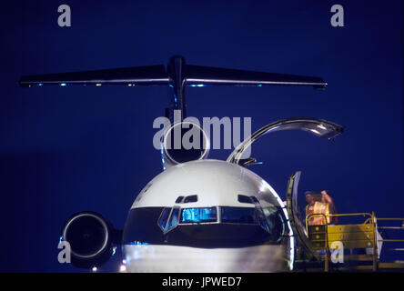 Les hommes portant des tabards jaune haut-viz debout près de la porte de soute ouverte, pare-brise, queue-fin et Rolls-Royce Tay moteur 651-54 sur UPS Boeing 727-100QF à Banque D'Images