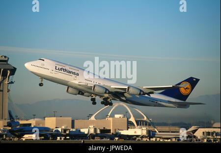 Boeing 747-400 de Lufthansa le décollage, Delta Air Lines McDonnell Douglas MD-1 et 727-200 stationné au terminal avec le contrôle du trafic aérien et le clocher Banque D'Images