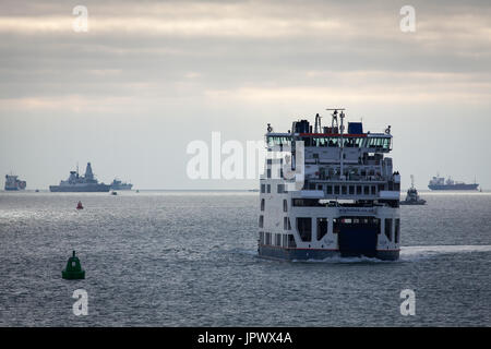 Le car-ferry Wightlink, sainte Claire, approchant le port de Portsmouth que le HMS Diamond, le destroyer de la Marine royale, voiles derrière dans la distance Banque D'Images