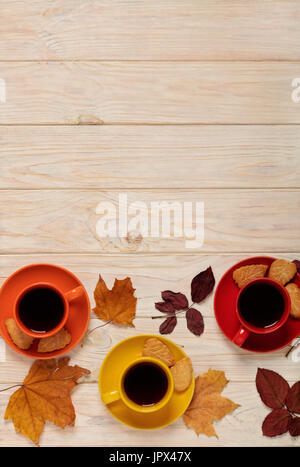 Concept de l'automne. Tasses de café avec biscuits dans la forme des feuilles et des feuilles d'automne sur un fond en bois clair. Focus sélectif. Banque D'Images