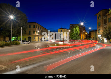 La lumière de voiture traine sur le carrefour pendant la nuit dans la ville d'Umbertide, Italie Banque D'Images