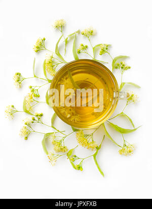 Thé de fleurs de tilleul avec les inflorescences de tilleuls autour d'une tasse sur un fond blanc. Vue d'en haut. Photo verticale Banque D'Images