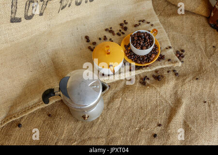 Alice Superiore, Italie - 01 août, 2017 : châssis sur moka italienne et les grains de café dans la tasse. Vintage style de vie, encore en sac de jute backgrou Banque D'Images