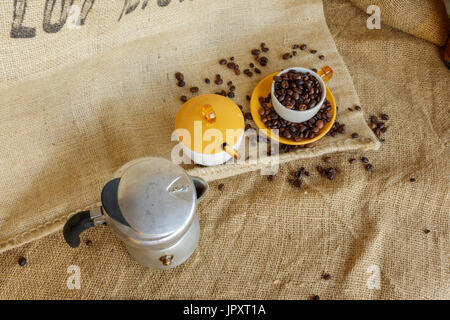 Alice Superiore, Italie - 01 août, 2017 : châssis sur moka italienne et les grains de café dans la tasse. Vintage style de vie, encore en sac de jute backgrou Banque D'Images