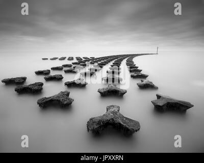 Une longue exposition de droit de défense de la mer à Felixstowe. Banque D'Images