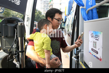 Chongqing, Chine, la municipalité de Chongqing. 3e août, 2017. Un passager paie pour billet de bus par quick response (QR) code dans Jiangbei District, municipalité de Chongqing en Chine du sud-ouest, du 3 août 2017. Les paiements mobiles l'exploitation a commencé dans certaines lignes de bus à Chongqing. Les passagers peuvent payer les tickets de bus en scannant les codes QR. Credit : Qin Tingfu/Xinhua/Alamy Live News Banque D'Images