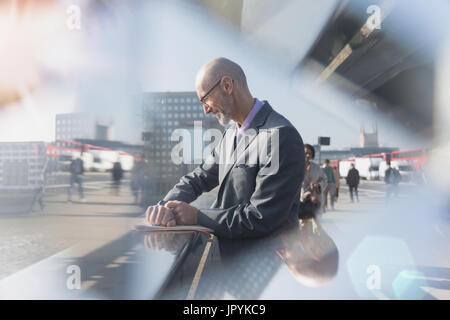 Businessman checking smart watch on urban street Banque D'Images