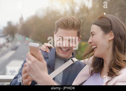 Couple qui riait avec selfies téléphone appareil photo Banque D'Images