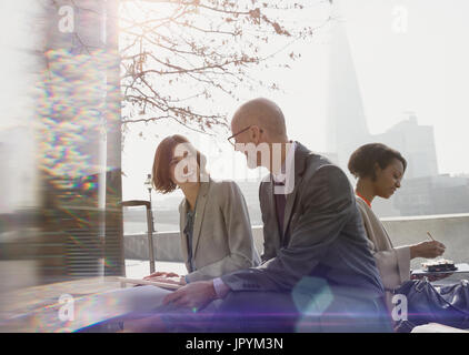 Businessman and businesswoman talking, salles à sunny parc urbain Banque D'Images