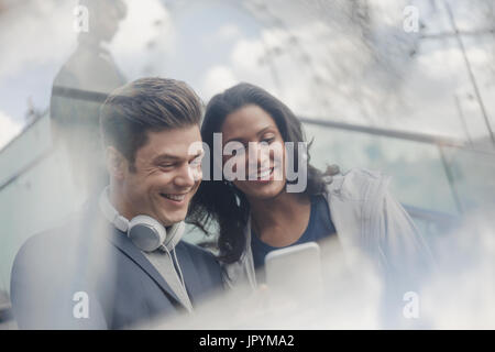 Couple avec un casque using cell phone Banque D'Images