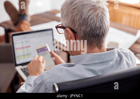 Businessman working, using cell phone in office Banque D'Images