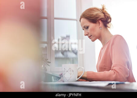 L'accent grave, businesswoman working at digital tablet Banque D'Images
