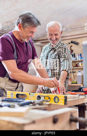 Male de mesure et de marquage des menuisiers bois sur l'établi dans l'atelier Banque D'Images