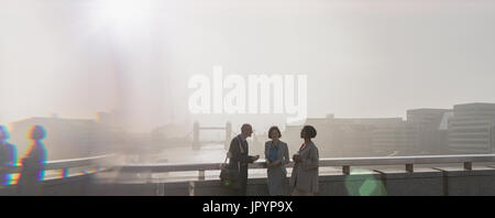 Les gens d'affaires Silhouette urbaine ville ensoleillée sur le pont au-dessus de la rivière Thames, London, UK Banque D'Images